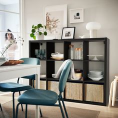 a dining room table with chairs and shelves