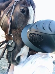 a horse with a helmet on it's head is being held by a man