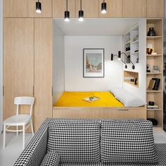 a small room with a bed, couch and bookshelf