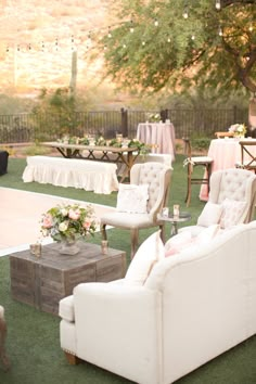 an outdoor reception with white couches and tables