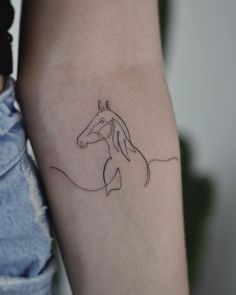 a woman's arm with a horse tattoo on the left side of her arm