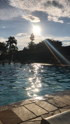 the sun shines brightly over an empty swimming pool