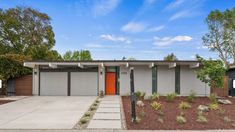 a modern home with two garages in the front yard