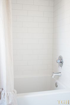 a white bath tub sitting next to a shower curtain