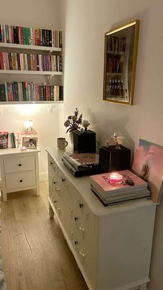 a bedroom with bookshelves, desk and bed in the corner next to it