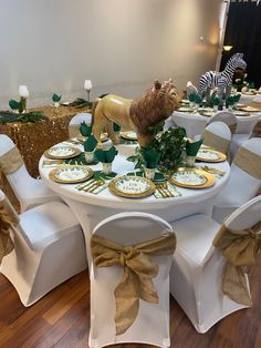 a table set up for a party with white chairs and gold chargers on the tables