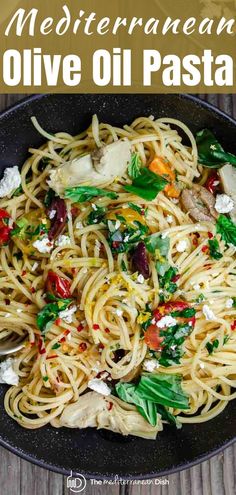 a plate of pasta with olives and fettuccine on top, in a skillet