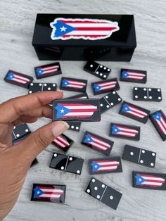 a hand is pointing at several dominos with the flag on them and one has been placed