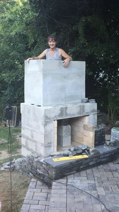 a woman standing on top of a brick oven