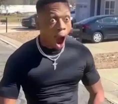 a man making a surprised face while standing on the sidewalk in front of a house