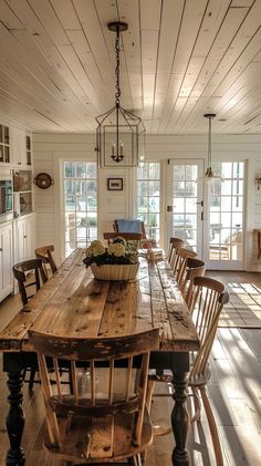 a large wooden table sitting in the middle of a room with lots of chairs around it