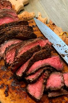 sliced meat on a cutting board with a knife