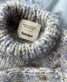 a close up of a knitted sweater with a label on the front and bottom