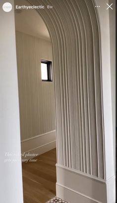 an arch is shown in the middle of a room with white walls and wood floors