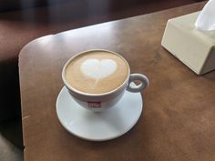 a cappuccino on a saucer with a heart drawn in the foam