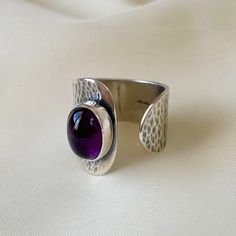 This 925 Sterling Silver band ring is purely handmade and natural Amethyst is used as gemstone. The surface of the ring has forged and oxidized finish to create the rustic and authentic look. Amethyst:   * meditation stone * physical and spiritual healing * calms the mind and spirit * eases stress caused tensions and pain * supports sleep * brings inner peace * mental clarity * intuition * attracts the divine energy * chakra cleansing * protection from negativity * balances endocrine and circula Adjustable Wide Band Hallmarked Rings, Adjustable Hallmarked Wide Band Rings, Amethyst Rings With Polished Finish For Gift, Handmade Sterling Silver Amethyst Ring, Unique Amethyst Open Ring For Anniversary, Unique Amethyst Adjustable Rings, Unique Adjustable Amethyst Ring In Sterling Silver, Unique Adjustable Amethyst Ring, Adjustable Sterling Silver Amethyst Ring