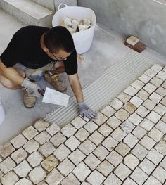 a man is working on some bricks outside