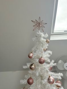 a white christmas tree with pink and gold ornaments