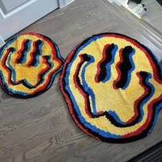 two round rugs on the floor in front of a door, one with an image of a man's face