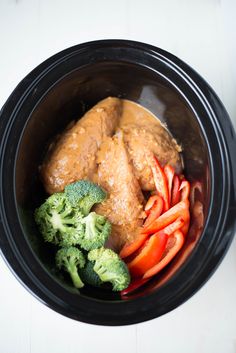 a bowl filled with meat and vegetables on top of a table