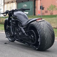 a black motorcycle parked on the street next to a building