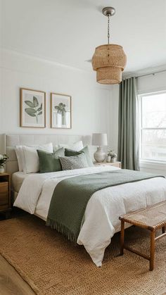 a bedroom with a large bed and two pictures on the wall above it, along with a wicker bench