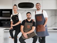 three people in aprons posing for the camera