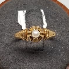 Vintage 14K Yellow Gold Art Deco Pearl Ring, Size 4.5. Not marked but tested positive as 14K. Pearl is 3.5mm. Ring is 7mm wide. Weighs 1.7 dwt. Are these stones real or fake? Aside from diamonds, we do not know if any gemstones are natural or synthetic. We will state on certain gemstones, that we know 100%, if they are created or fake due to their lack of inclusions. For this reason, we do not sell any diamonds without inclusions, and the larger diamonds (half ct+) are soft graded. In recent years, synthetic gemstones are being created to pass the hardness tests, which is why we state clear rubies and emeralds to be created.  In regards to Star Sapphires, typically, a genuine Star Sapphire's star will follow a light source that is shining on it, while created ones stay stationary. In recen Victorian 14k Gold Diamond Cut Rings, Antique Yellow Gold 14k Pearl Ring, Antique Gold Pearl Ring In 14k Gold, Antique 14k Stamped Pearl Ring Gift, Antique Oval Pearl Ring Stamped 14k, Antique Yellow Gold Pearl Ring, Gold 14k Hallmarked Pearl Ring, Antique Yellow Gold Oval Pearl Ring, Antique Oval Yellow Gold Pearl Ring