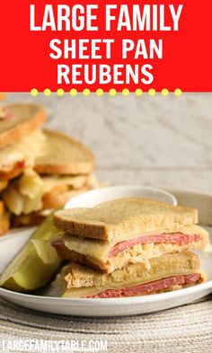 a white plate topped with a cut in half sandwich next to pickle wedges