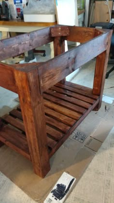 a wooden bench sitting on top of a floor next to a table with a mirror