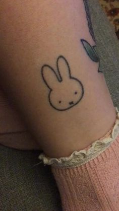 a woman's leg with a tattoo of a rabbit on the back of her leg