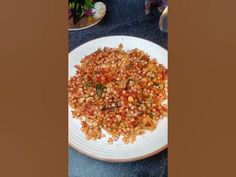 a white plate topped with lots of food on top of a blue tablecloth covered table