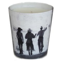 a candle that is sitting in front of a glass with two men on the side