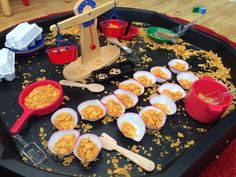 a tray filled with lots of food on top of a table next to bowls and spoons