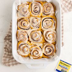 a baking dish filled with cinnamon rolls next to a packet of buttermilks