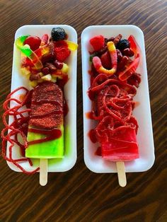 two trays filled with different types of food on top of a wooden table next to each other