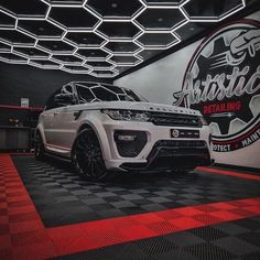 a white range rover is parked in front of a sign that says arctic racing on it