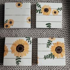 four sunflowers painted on white wooden boards