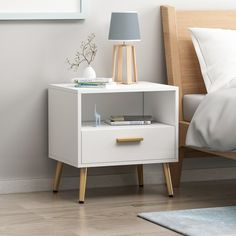 a night stand with two drawers and a lamp next to it on a wooden floor