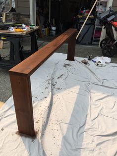 a wooden bench sitting on top of a white sheet