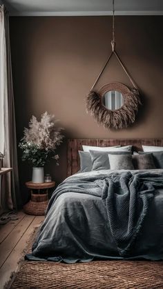 a bedroom with a bed, mirror and plants on the wall next to window sill