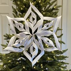 a christmas tree decorated with white paper snowflakes