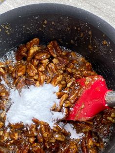 the food is being cooked in the pot on the stove top and stirred with salt