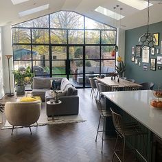 a living room filled with lots of furniture next to a kitchen and dining room table