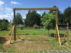 an empty swing set in the middle of a field