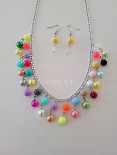 a necklace and earring set with multicolored beads on a white table top