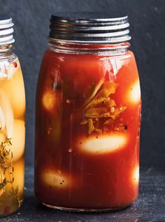 two jars filled with food sitting next to each other