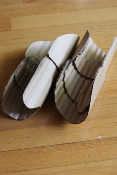 two pieces of cardboard sitting on top of a wooden floor