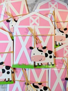 pink and white paper cutouts with black and white cow on them, tied to twine