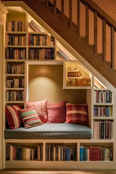 a bookshelf filled with lots of books next to a stair case